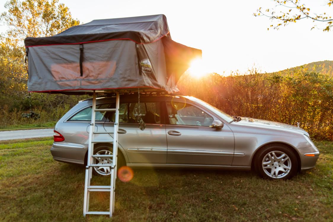 Aufgeklapptes Dachzelt auf einem Auto auf einem Campingplatz