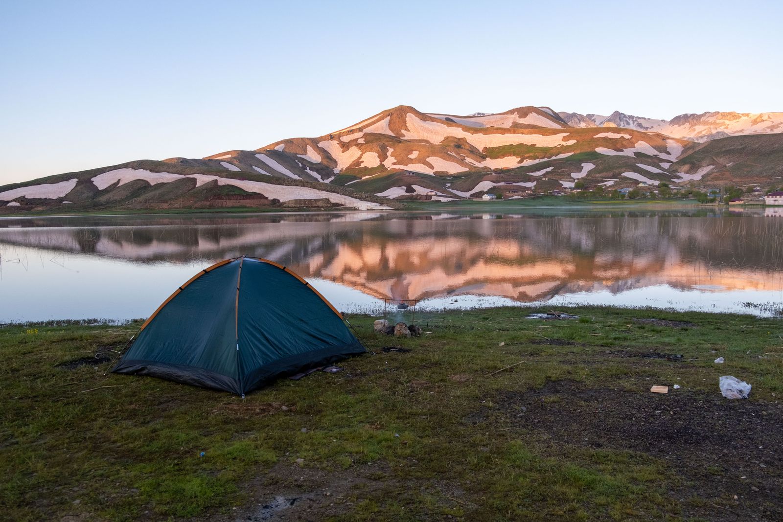 Zelt an einem Bergsee im Morgenlicht